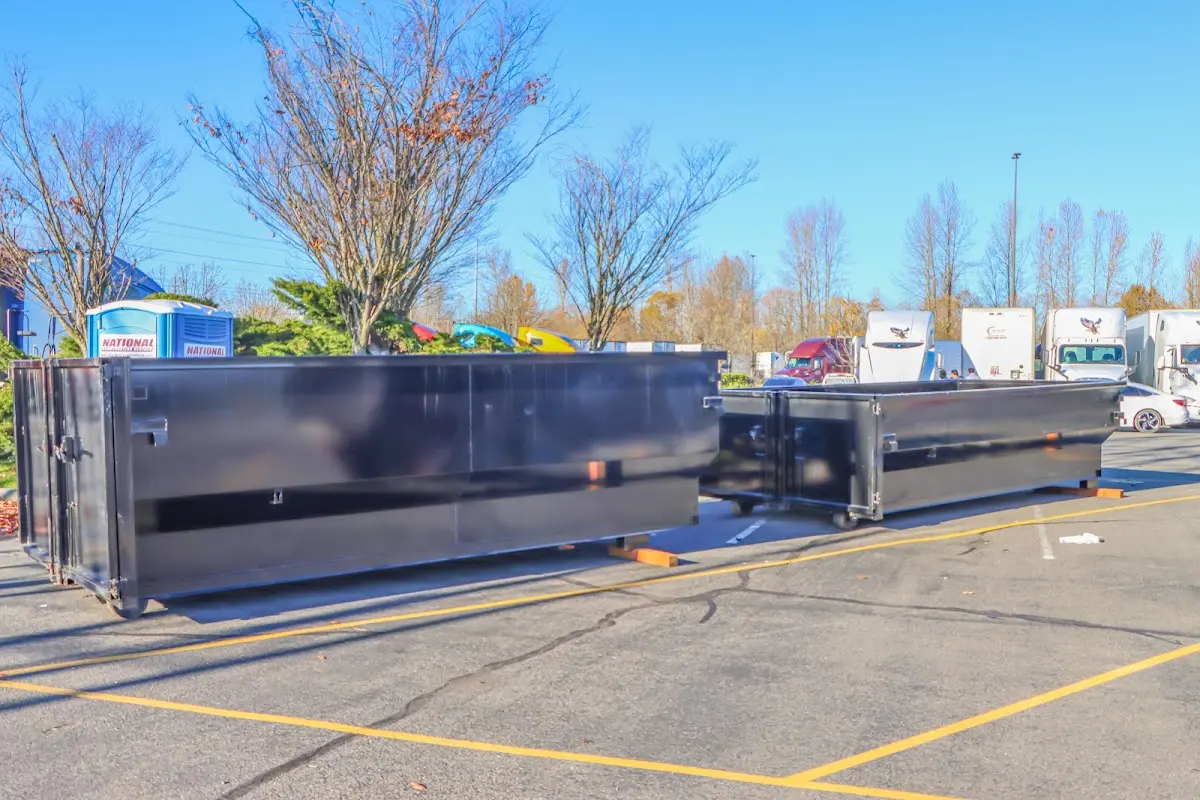 Professional dumpster rental service with roll-off container on residential driveway in Plains